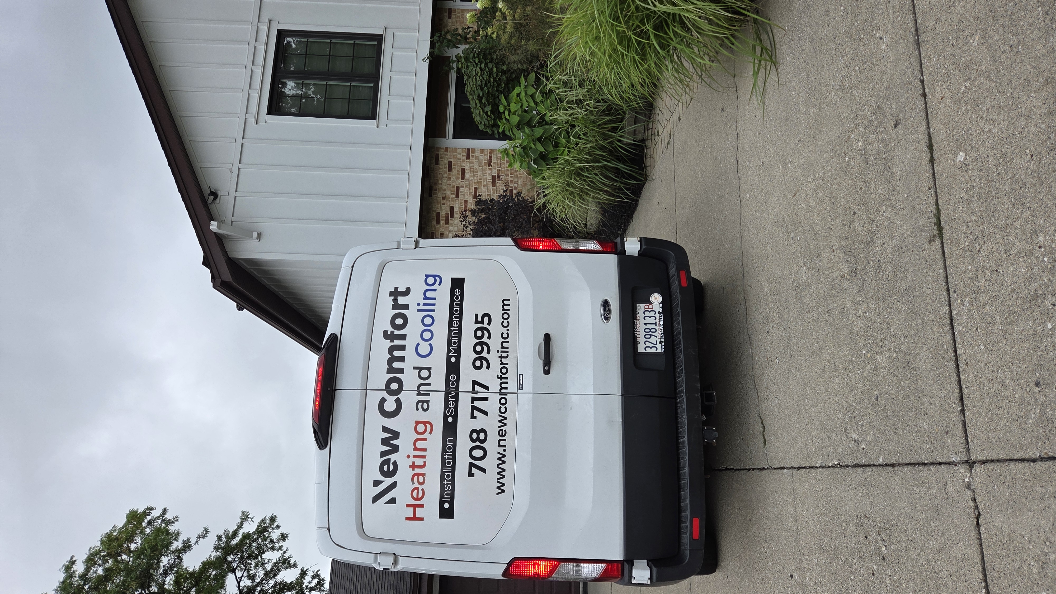 New Comfort Heating and Cooling service van parked in a customer driveway for an HVAC service call