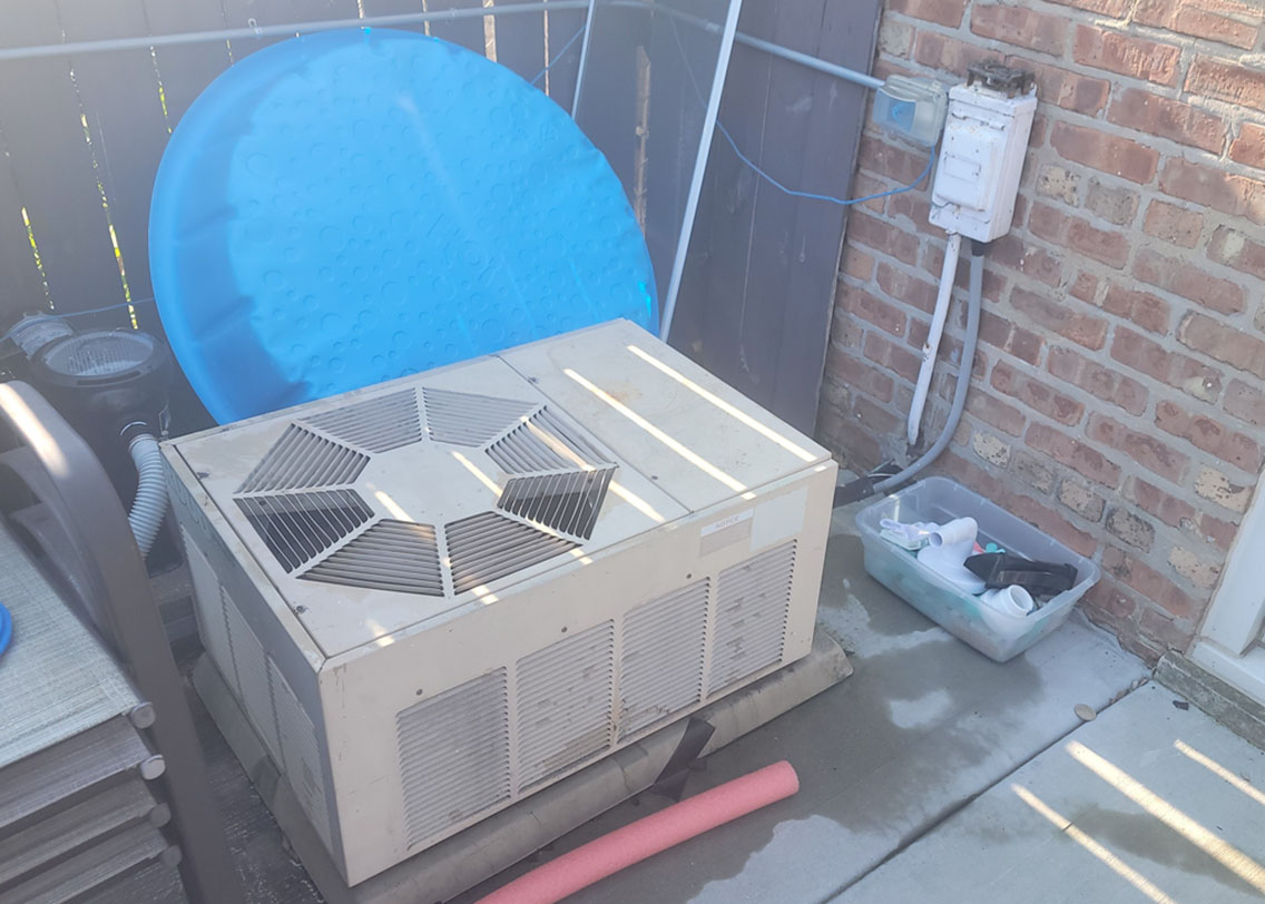 Old, worn outdoor air conditioner unit before replacement at a Chicago-area home