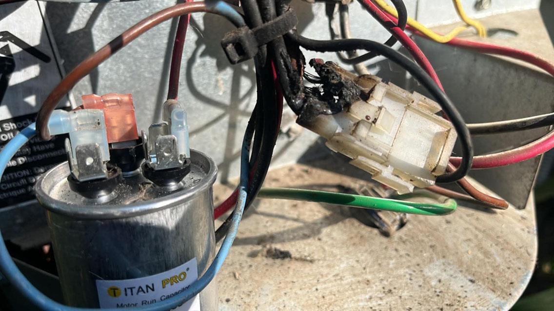 Burned wiring connector next to a run capacitor found during an emergency AC repair call
