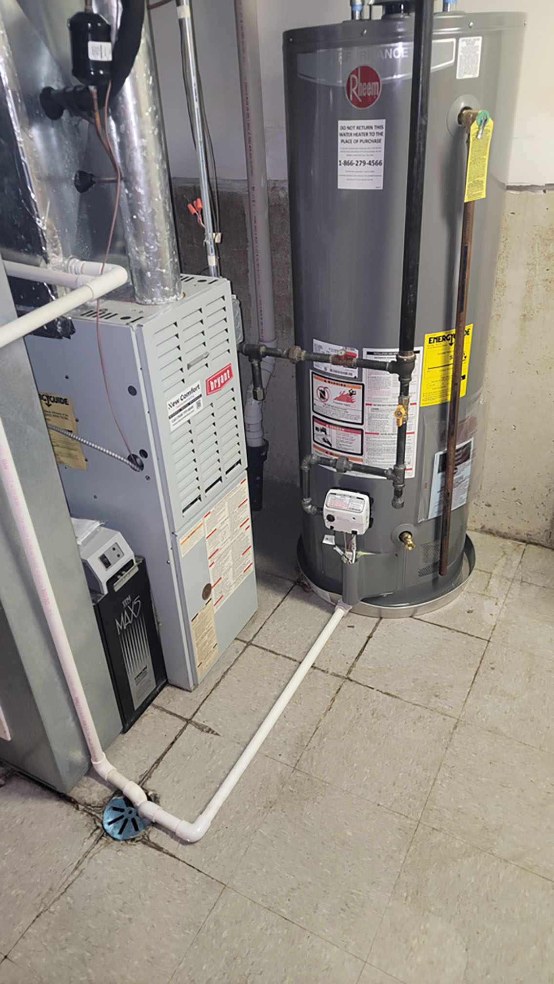 Gas furnace and new water heater installed side by side in a basement utility area